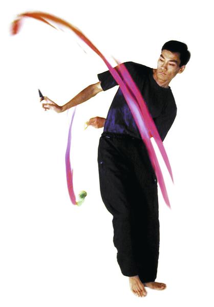 Mann zeigt Jonglierkunst mit buntem Band und Diabolo vor weißem Hintergrund.