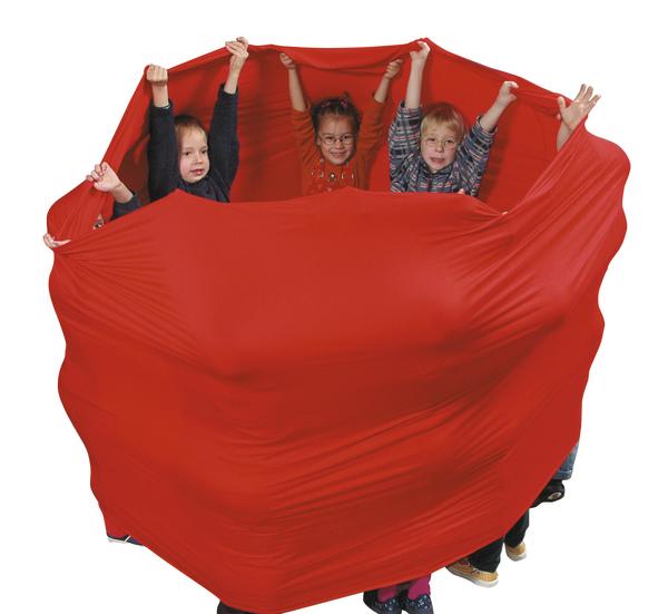 Kinder spielen gemeinsam mit rotem Stretch-Tuch in einer Gruppe, Teamaktivität drinnen.