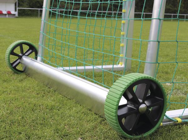 Mobiles Fußballtor  mit grünen Rädern auf gepflegtem Sportplatz.