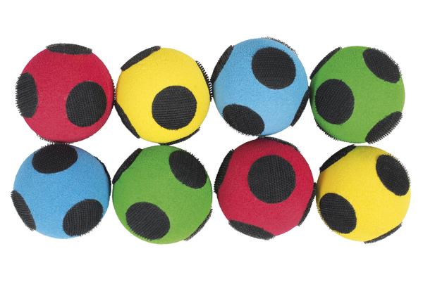 Bunte Jonglierbälle in Rot, Gelb, Blau und Grün mit schwarzen Punkten, isoliert auf Weiß.