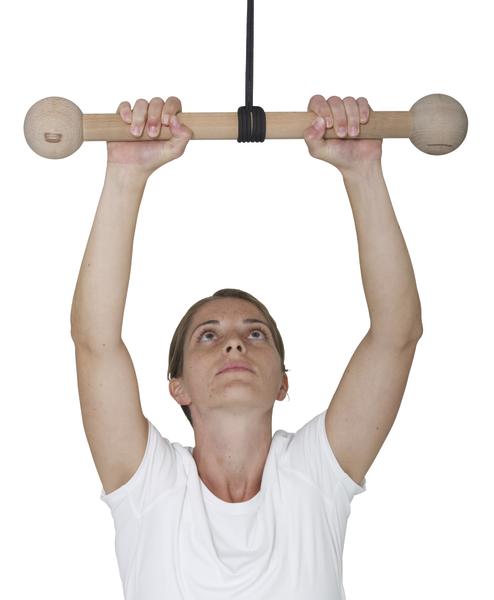 Frau hält Holzgriff an der Decke für Fitness- oder Rehabilitationsübungen, weißes T-Shirt.