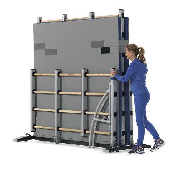 Frau faltet klappbare Kletterwand mit Holzgriffen für Fitness und Training zusammen.