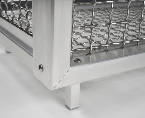 Eckdetail eines Edelstahlrahmens mit Drahtgitter und Standfuß auf weißem Hintergrund.