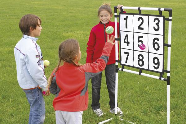 Kinder spielen im Freien ein Zielwurfspiel mit nummeriertem Spielfeld.