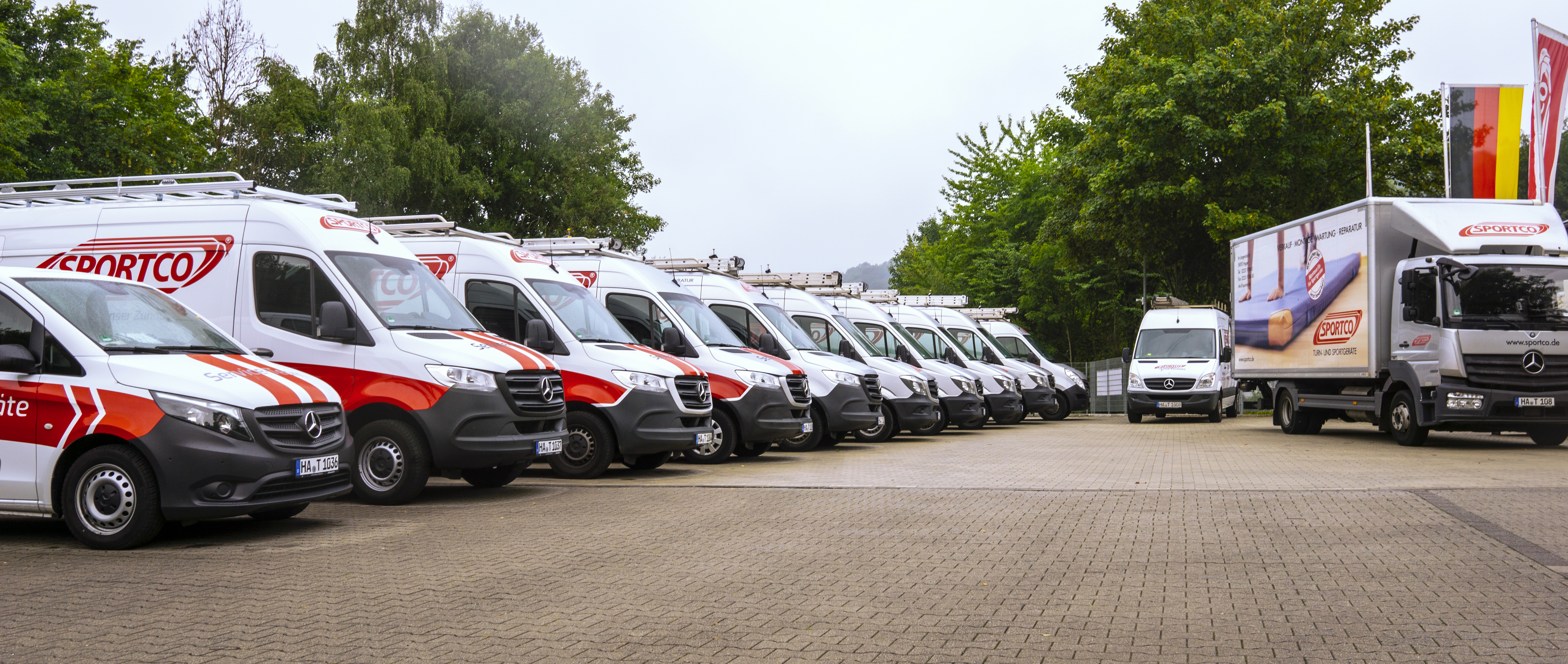 Sportco Firmenfahrzeuge stehen nebeneinander aufgereit auf dem Firmengelände.